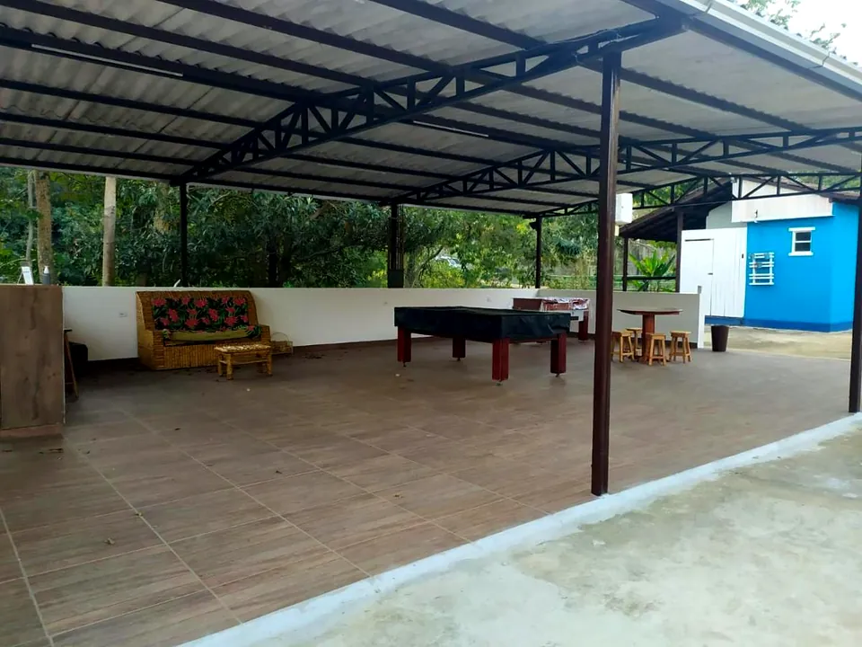 Área de jogos coberta durante o dia, com sinuca e mesa de pingue-pongue