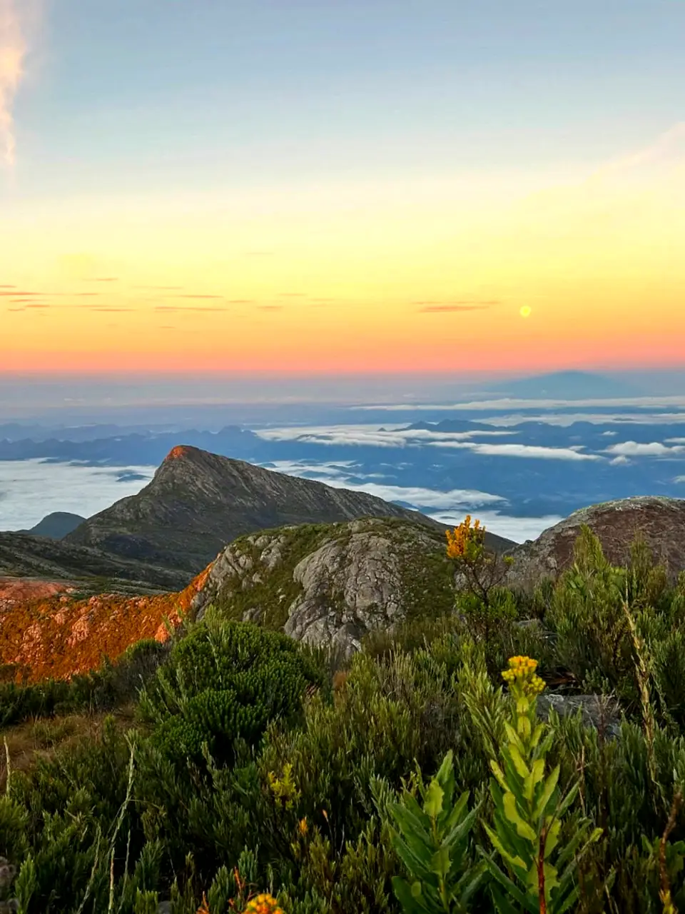 Nascer do sol visto do Pico do Cristal, com mar de nuvens sobre os vales